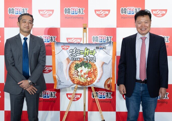 日清食品執行董事、董事長兼首席執行官安藤清隆先生(左)及韓印紅代表理事林栽華先生(右)一同主禮「葱葱辣麵」產品發佈會,祝願新產品大賣